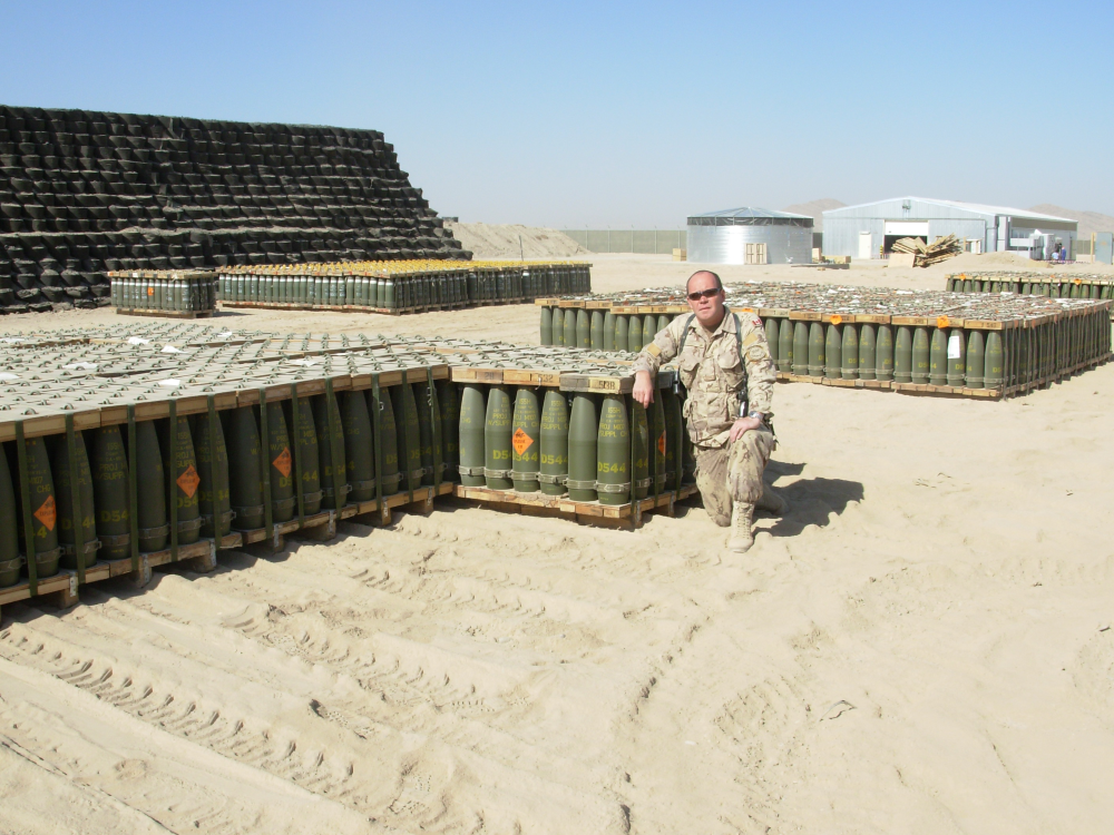 06-33 L-G-Ivey- Ebty BQMS Rick Cameron at KAF ammo compound with new shipments of 155mm.png